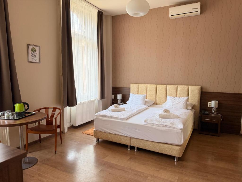 a bedroom with a bed and a table and a table sidx sidx sidx at Livora Boutique in Budapest