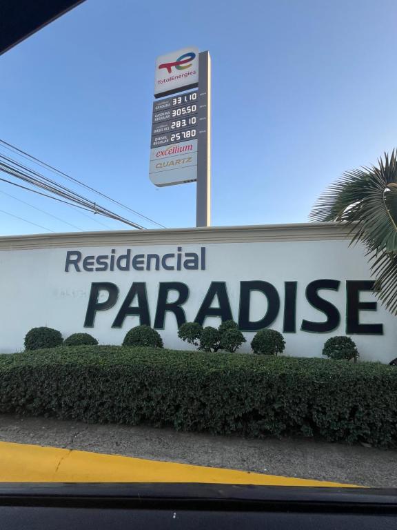 a sign for aresnatural parakeet on a building at Residencial Paradise in San Francisco de Macorís