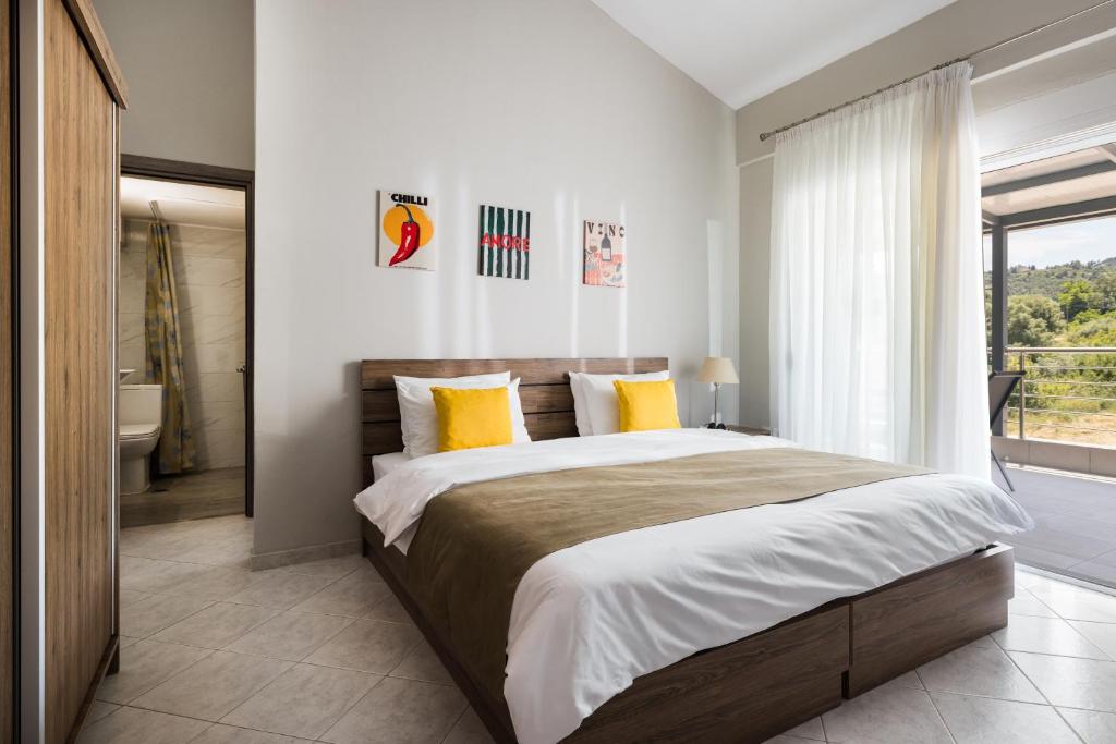a bedroom with a large bed with yellow pillows at Sakis in Polychrono