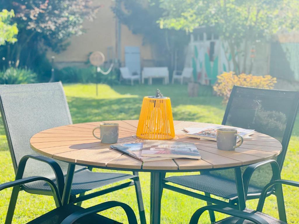 a wooden table with two chairs and a lamp on it at La Maison Le 14 - Un Jardin en Ville in Auxerre
