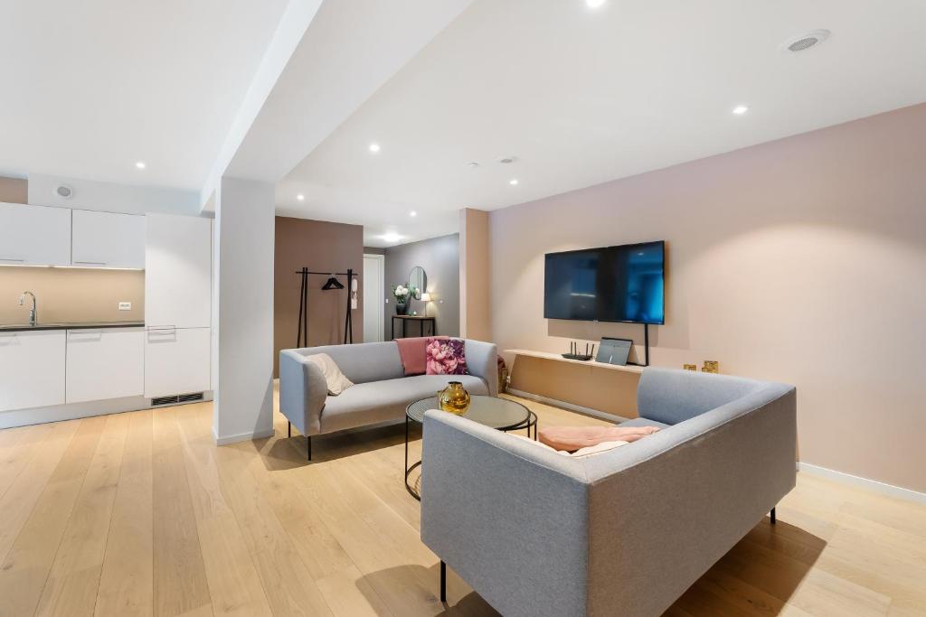 a living room with a couch and a tv at Stryn Apartments - City Center - Modern Suites in Stryn