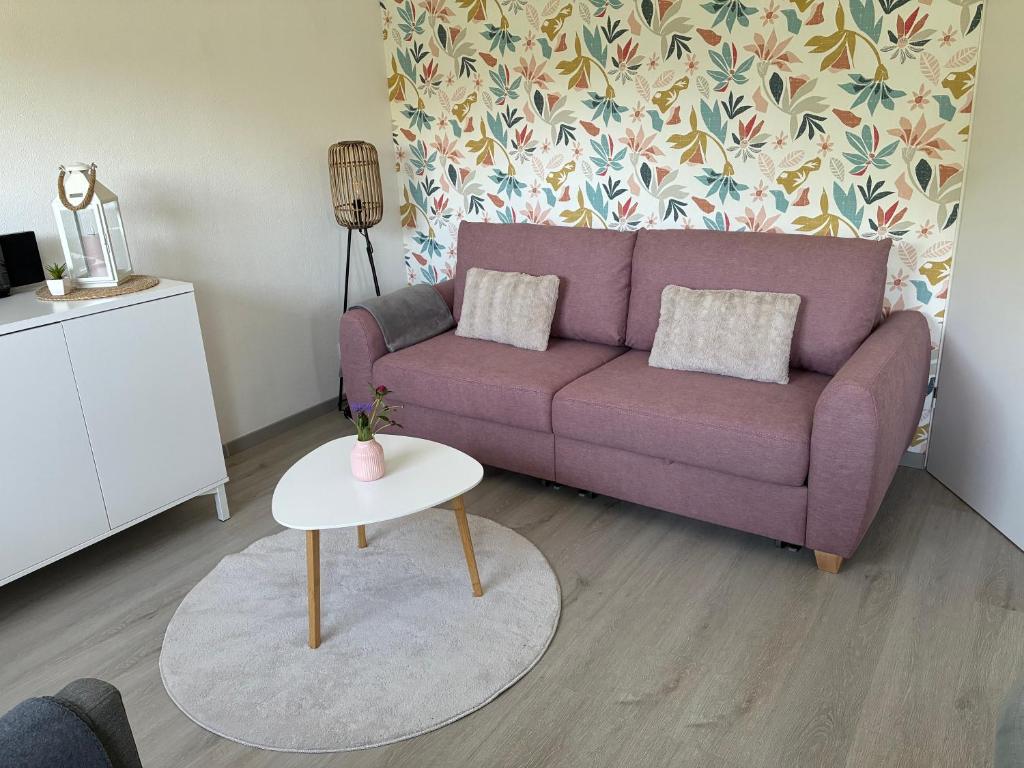 a living room with a purple couch and a table at Ferienwohnung -Diemelaue- in Warburg