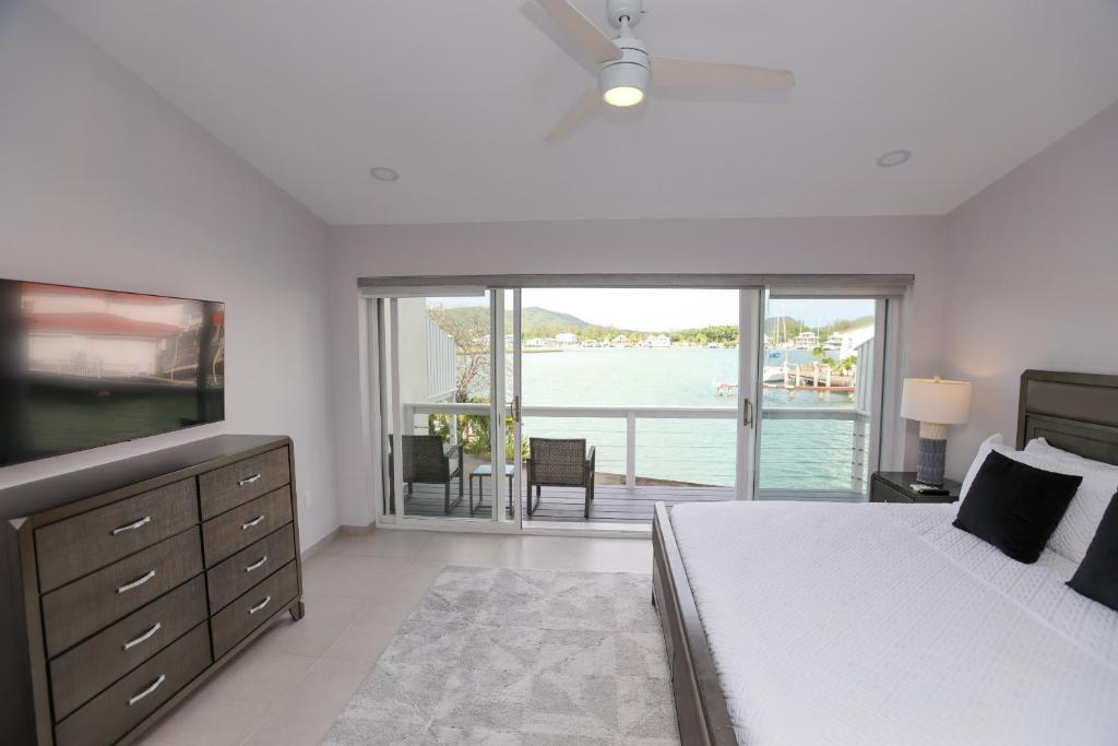 a bedroom with a bed and a view of the water at 232C South Finger in Jolly Harbour
