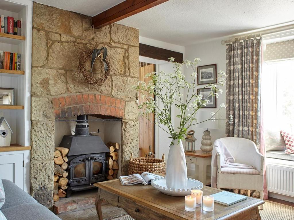 a living room with a stone fireplace with a vase on a table at 3 Bed in Niton oc-73299 in Niton