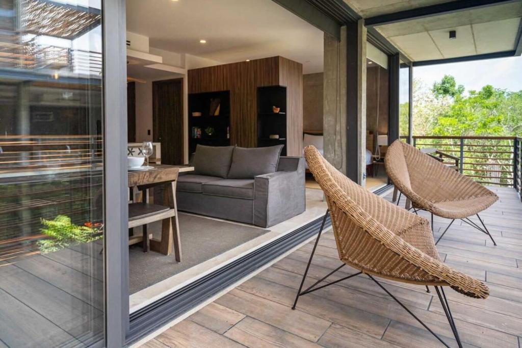 a living room with a couch and chairs on a patio at Ideal Location with Cenote Pools Gym Restaurant in Tulum