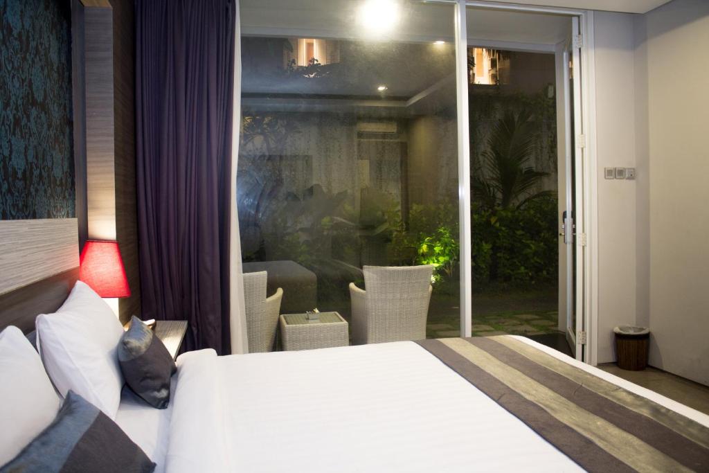 Postel nebo postele na pokoji v ubytování Transera Kamini Legian Hotel