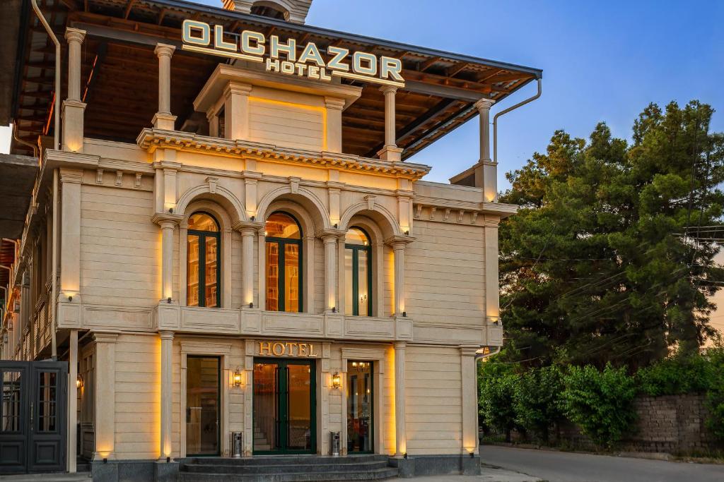 a building with a sign on top of it at Olchazor hotel in Tashkent