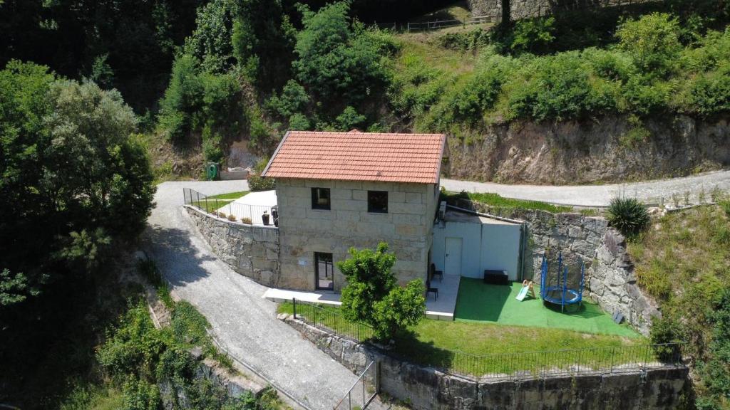 a small house on a hill next to a road at Teixeira Home - Gerês in Geres