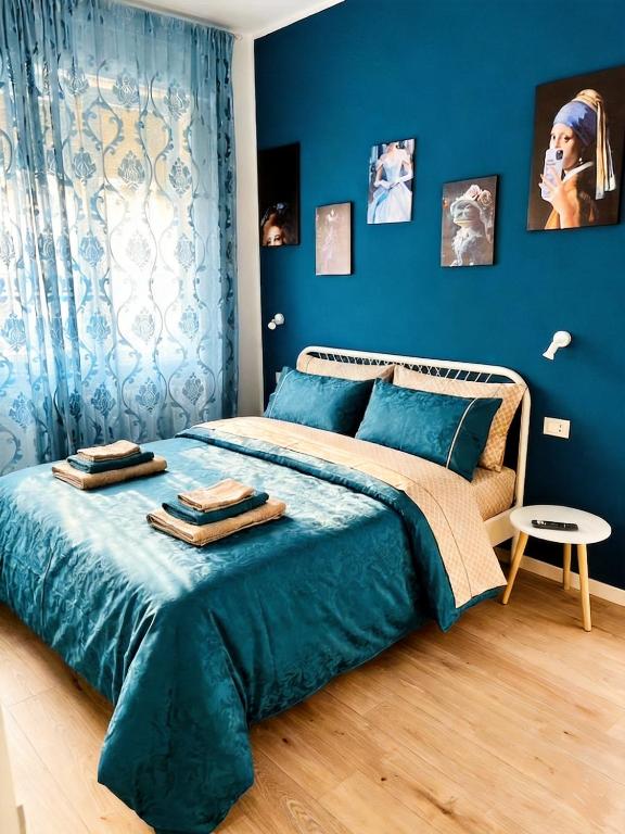 a bedroom with blue walls and a bed with blue sheets at Sea Breeze Suites in Livorno