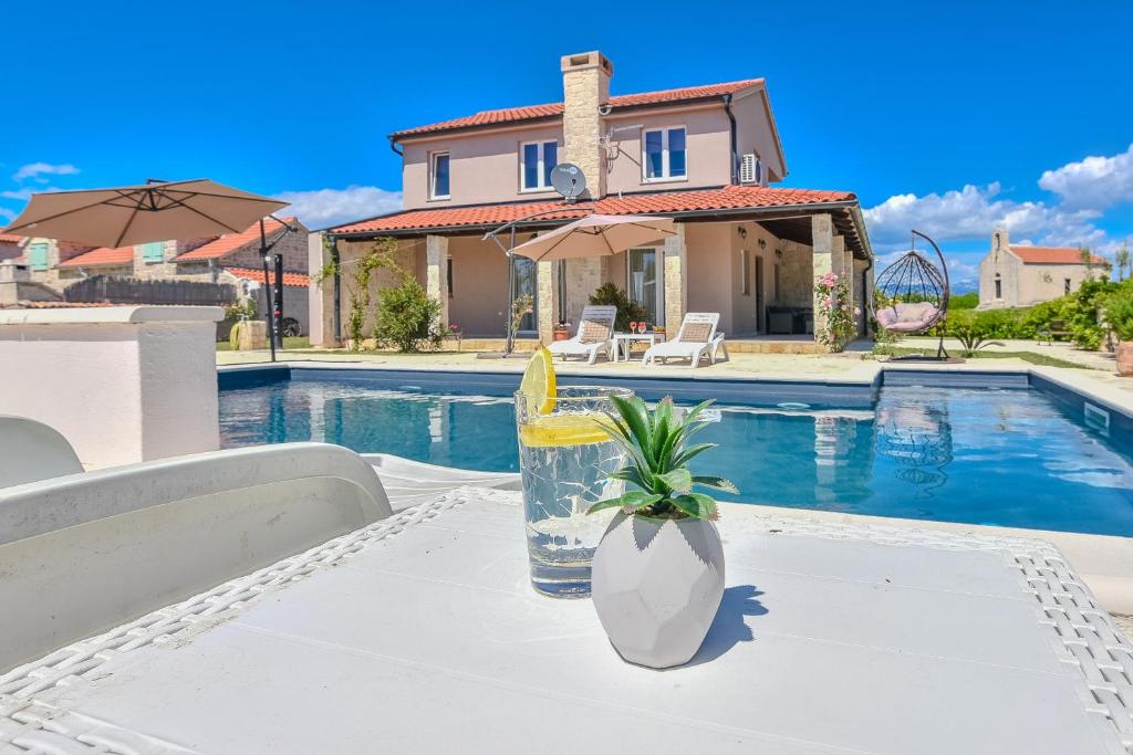 a villa with a swimming pool and a house at Casa di Marko-NEW MODERN RUSTIC HOUSE with pool AND SPACIOUS GARDEN! in Privlaka