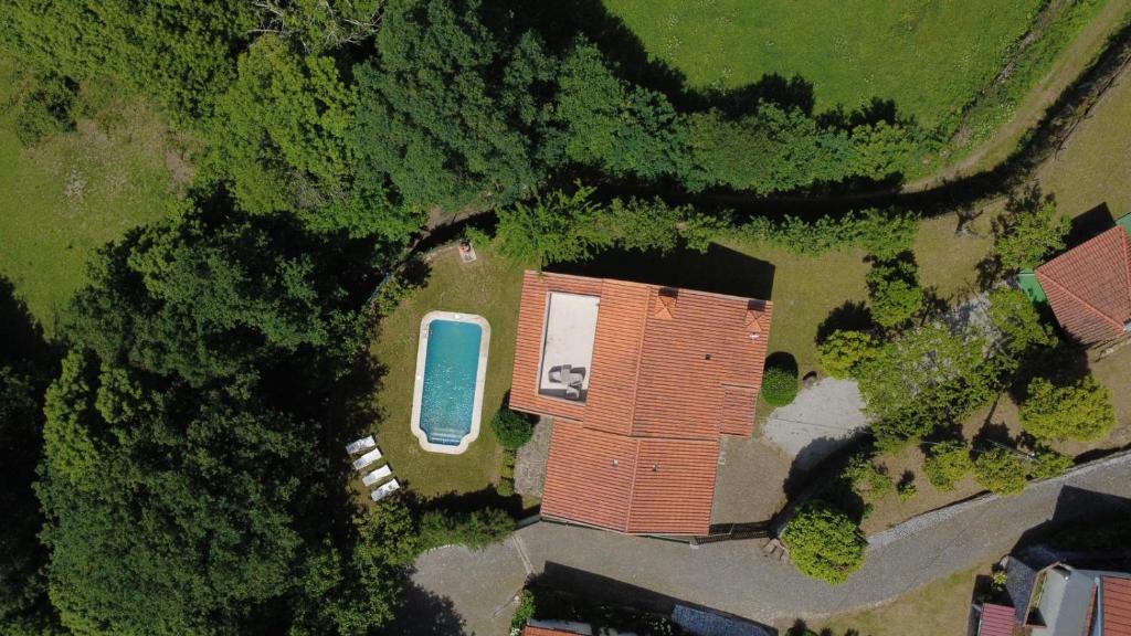 an overhead view of a house and a blue car at Sobreiros House - Gerês in Terras de Bouro