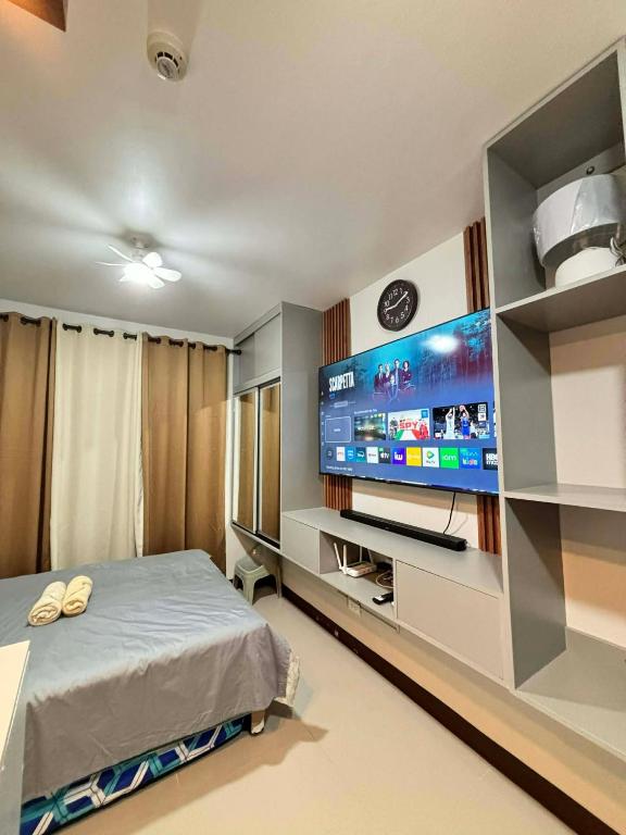 a bedroom with a flat screen tv and a bed at Pinili Homestay in Suba