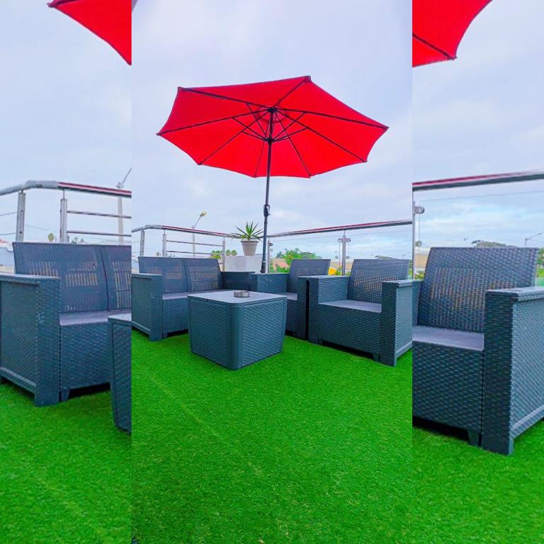 a patio with a red umbrella and some chairs at Quaaami in Cape Town