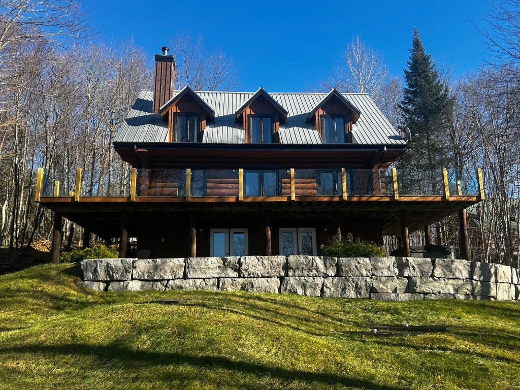 a large wooden house on top of a hill at Mont-Tremblant Mountain View Chalet in Lac-Superieur