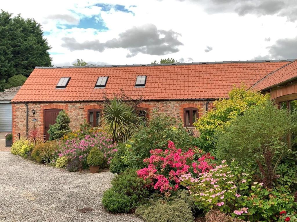 a brick house with a red roof and some flowers at 1 Bed in York oc-83265 in High Catton