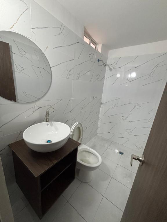 a white bathroom with a sink and a toilet at El Encanto in Valledupar