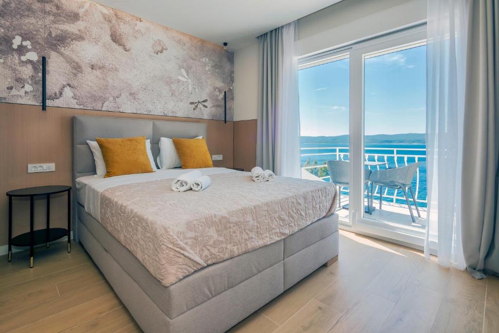 a bedroom with a bed and a large window at Skalinada Sea View in Lokva Rogoznica