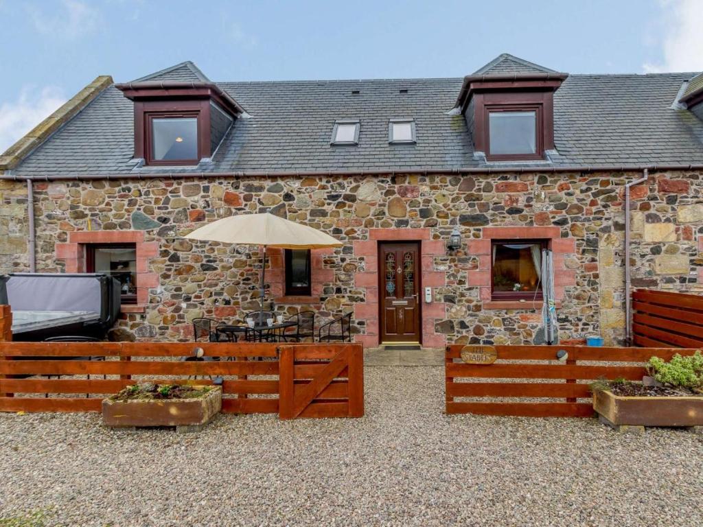 a brick house with an umbrella in front of it at 2 Bed in Perth oc-86059 in Forgandenny