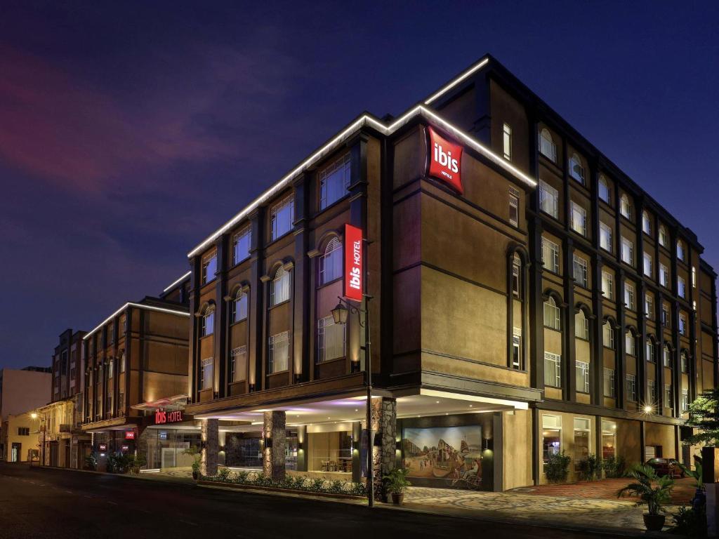a building with a sign on the side of it at Ibis Melaka in Malacca