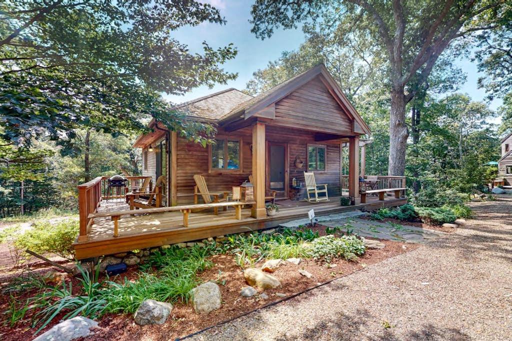 a small wooden cabin with a large porch at Nana's Rear Treehouse in West Tisbury