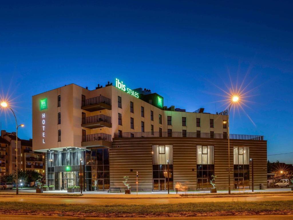 a building with a sign on top of it at night at ibis Styles Nowy Sacz in Nowy Sącz