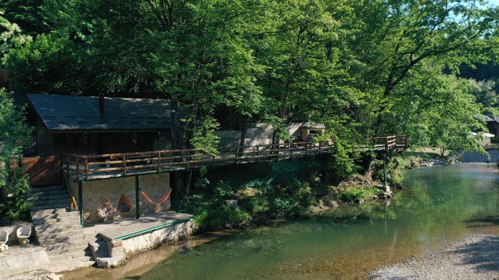 a bridge over a river with people sitting on it at Rzav, ti i ja. in Arilje