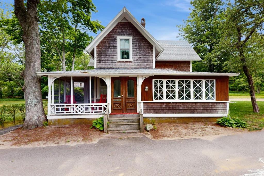 a small house with a red door and a tree at Beach House in Oak Bluffs