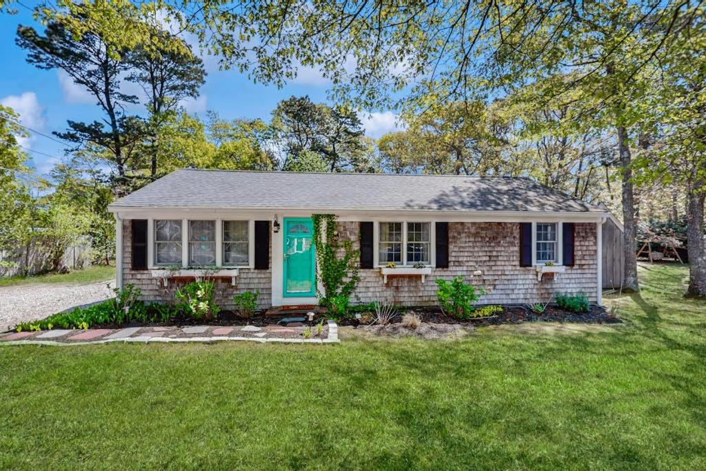 a house with a green door on a yard at Miles Away in South Dennis