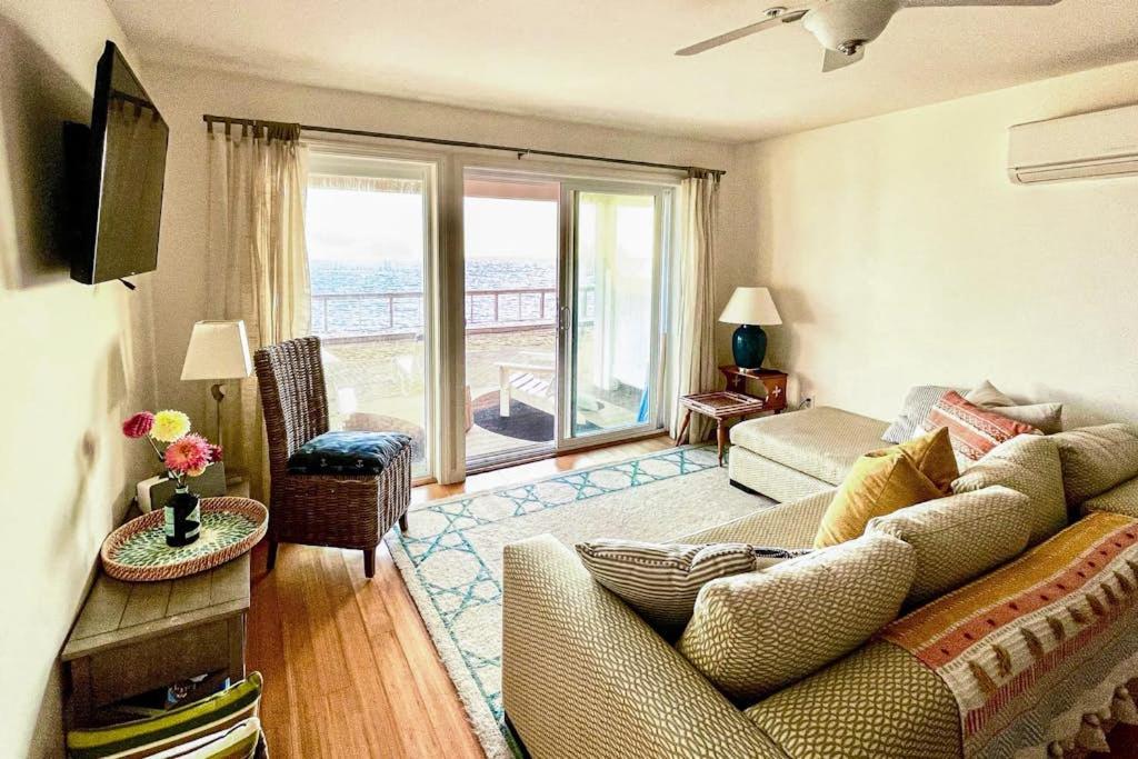 a living room with a couch and a large window at Bayside Beauty in Truro