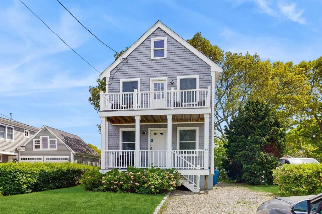 a white house with a porch and balcony at Bella Luna in Falmouth