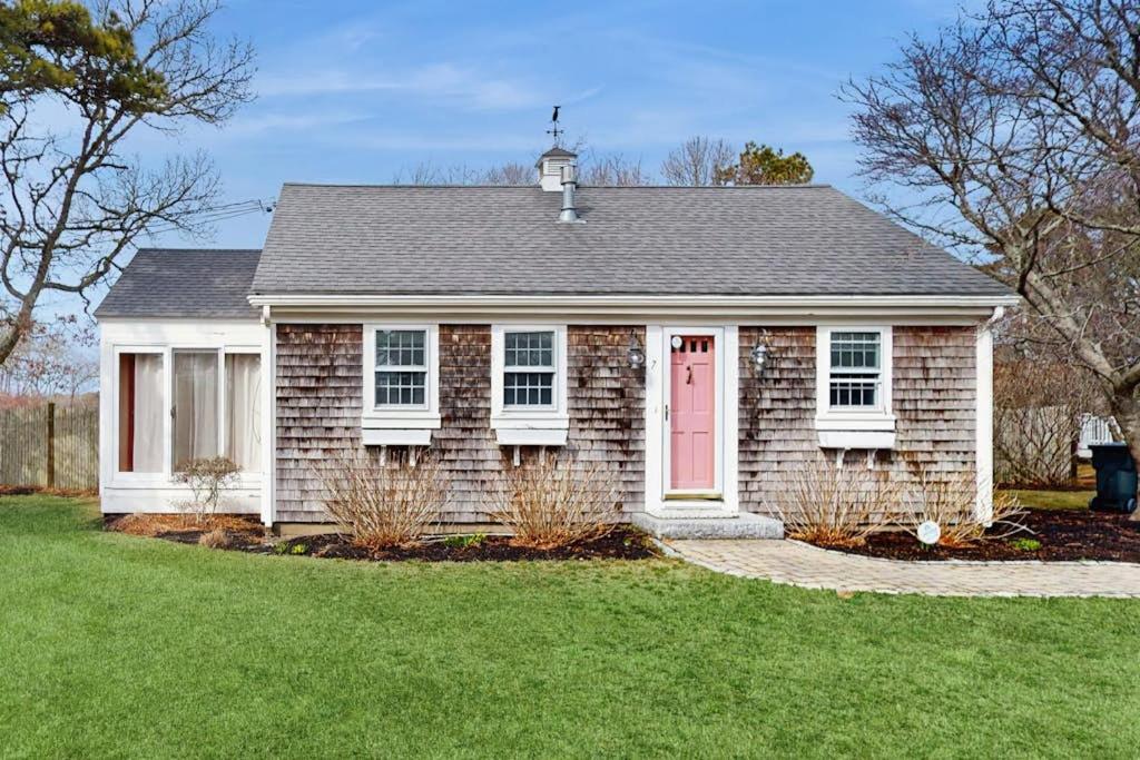a brick house with a red door and a grass yard at Lucky Number Seven in Chatham
