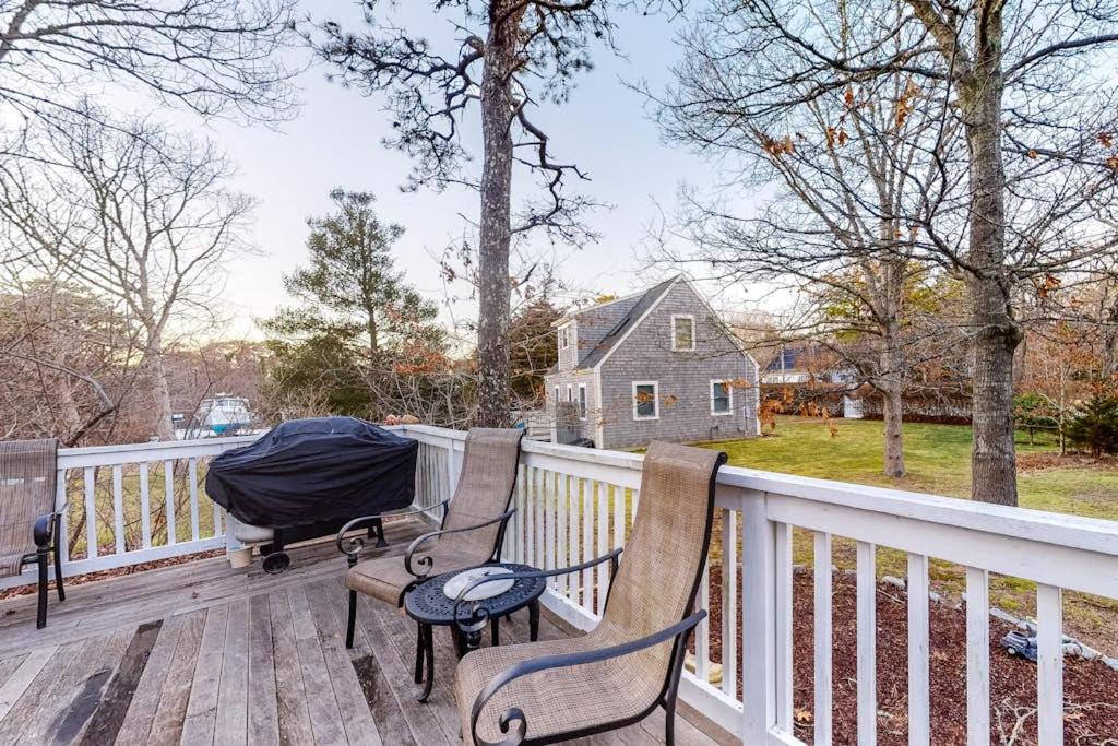 two chairs on a deck with a house in the background at Brewster House in Oak Bluffs