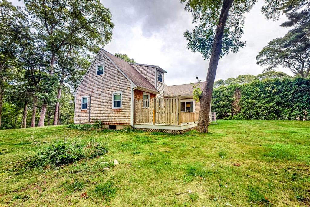a house in a field with a tree at Lake Shore Living in Falmouth
