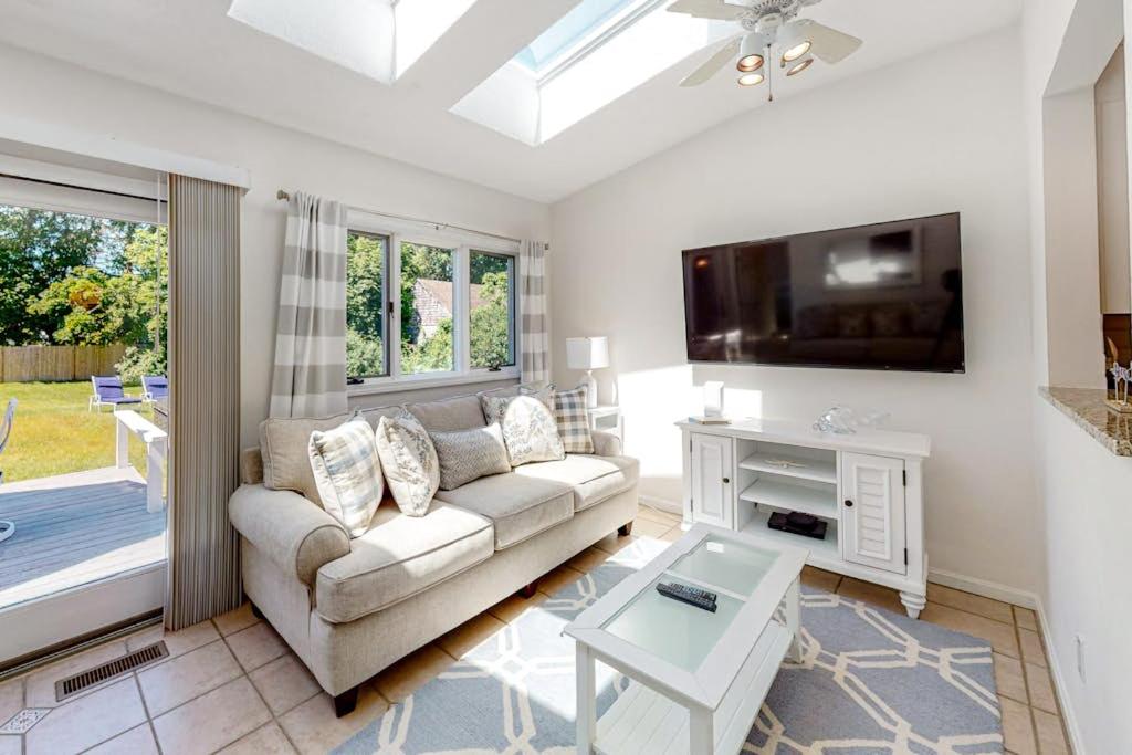 a living room with a couch and a tv at Sea You Later in West Yarmouth