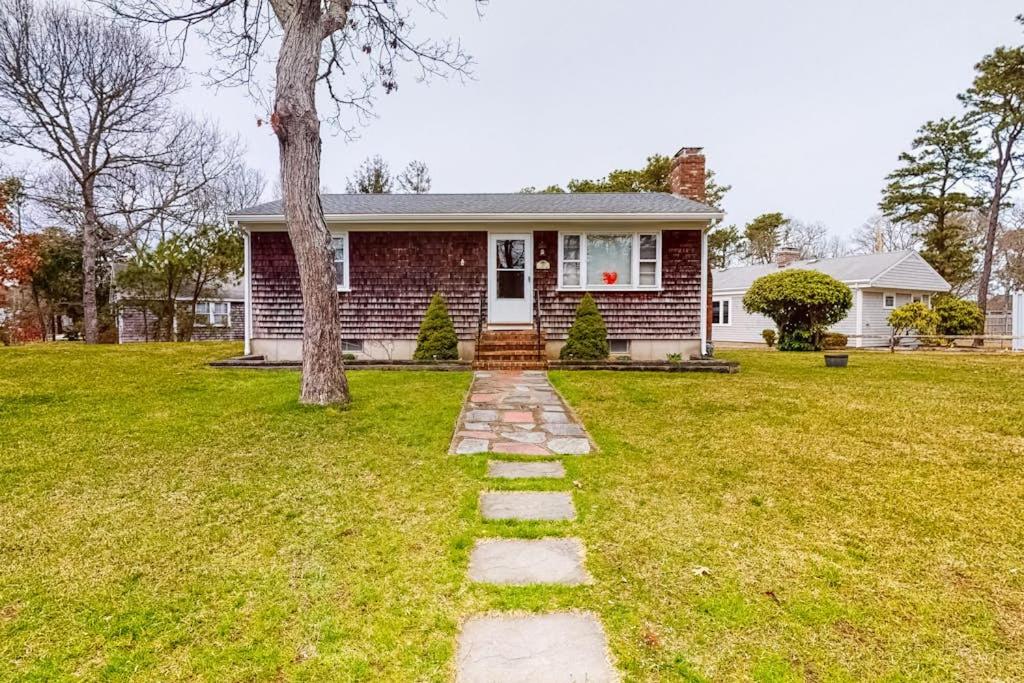 a brick house with a tree in the yard at Anchors Await in South Yarmouth