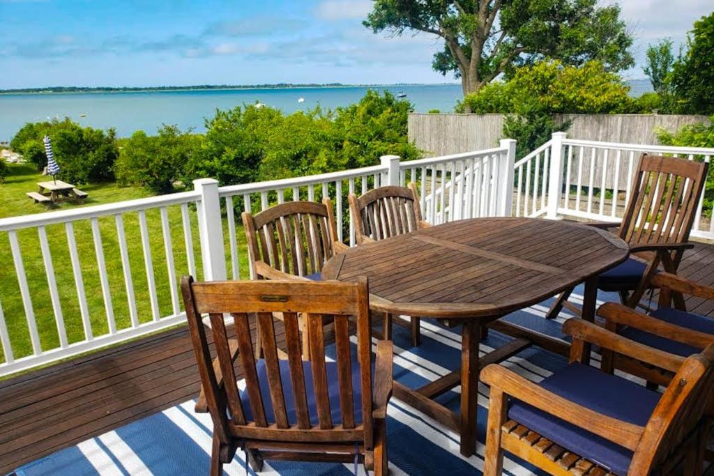 a wooden table and chairs on a deck at Barnstable Harbor Home in Barnstable