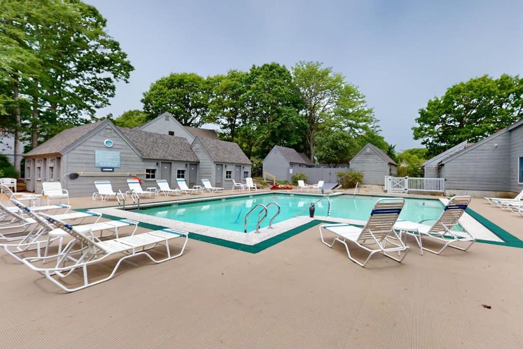 a swimming pool with chairs and a group at South Cape Escape in Mashpee