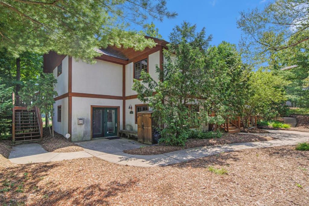 a large house with a driveway and trees at Boyne Mountain Getaway, Unit B in Boyne Falls