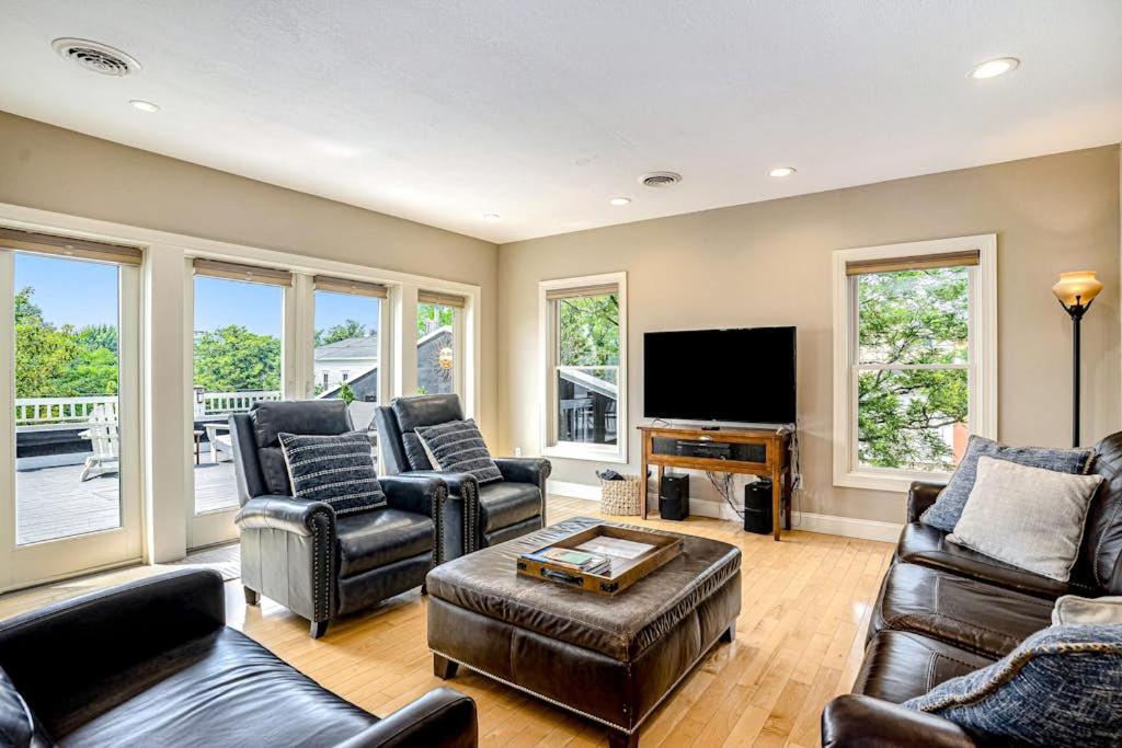 a living room with leather furniture and a flat screen tv at Lake View Getaway in Saugatuck