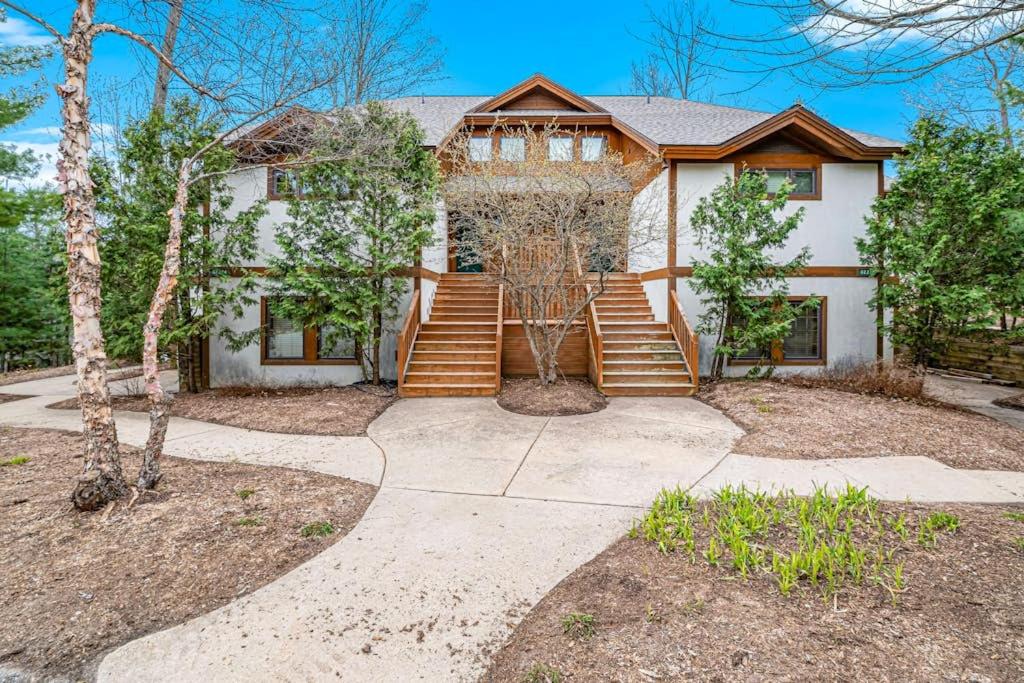 a house with a staircase in front of it at Boyne Mountain Getaway in Boyne Falls