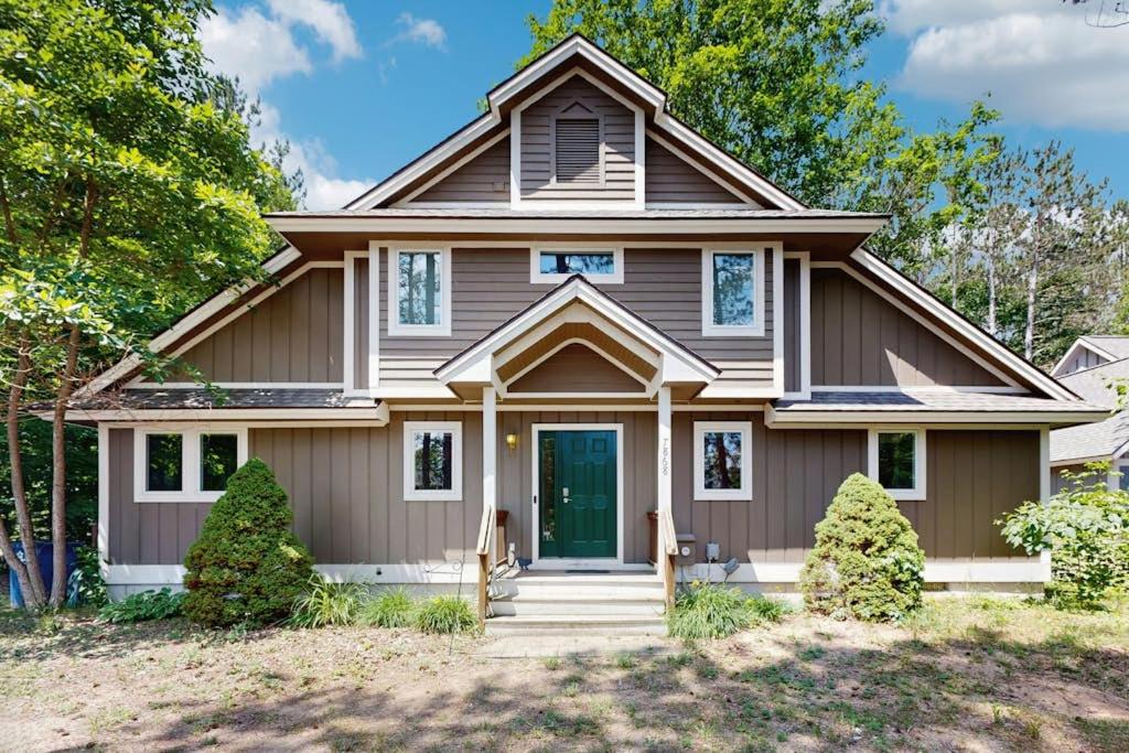 a house with brown siding and a green door at The Treehouse in Thompsonville