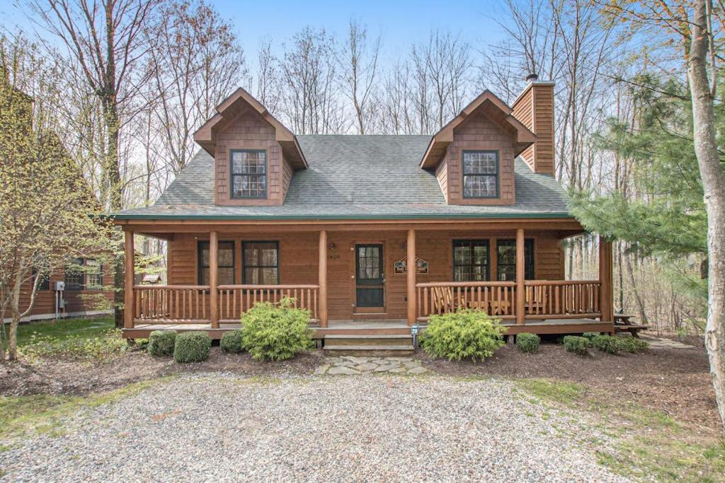 a large wooden house with a porch at Kingfisher Cove Cabin 28 in Saugatuck