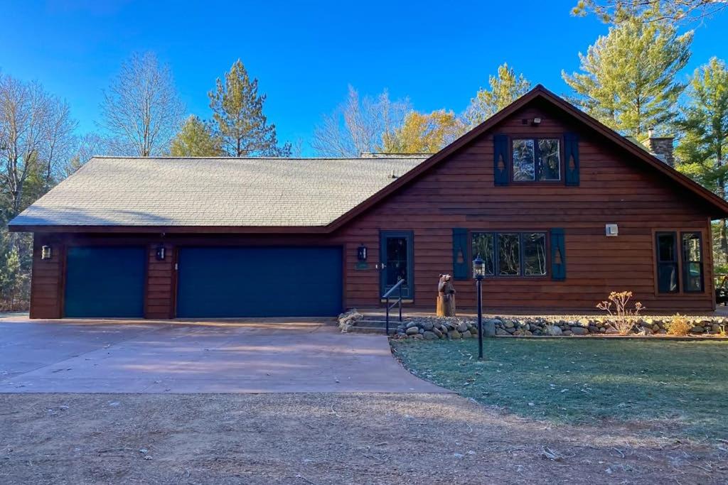 a wooden house with a garage on a driveway at Serenity at Stormy Lake in Conover