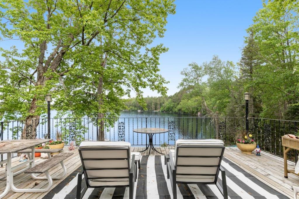 a deck with a table and chairs next to a lake at Northwoods Oasis in Land O' Lakes