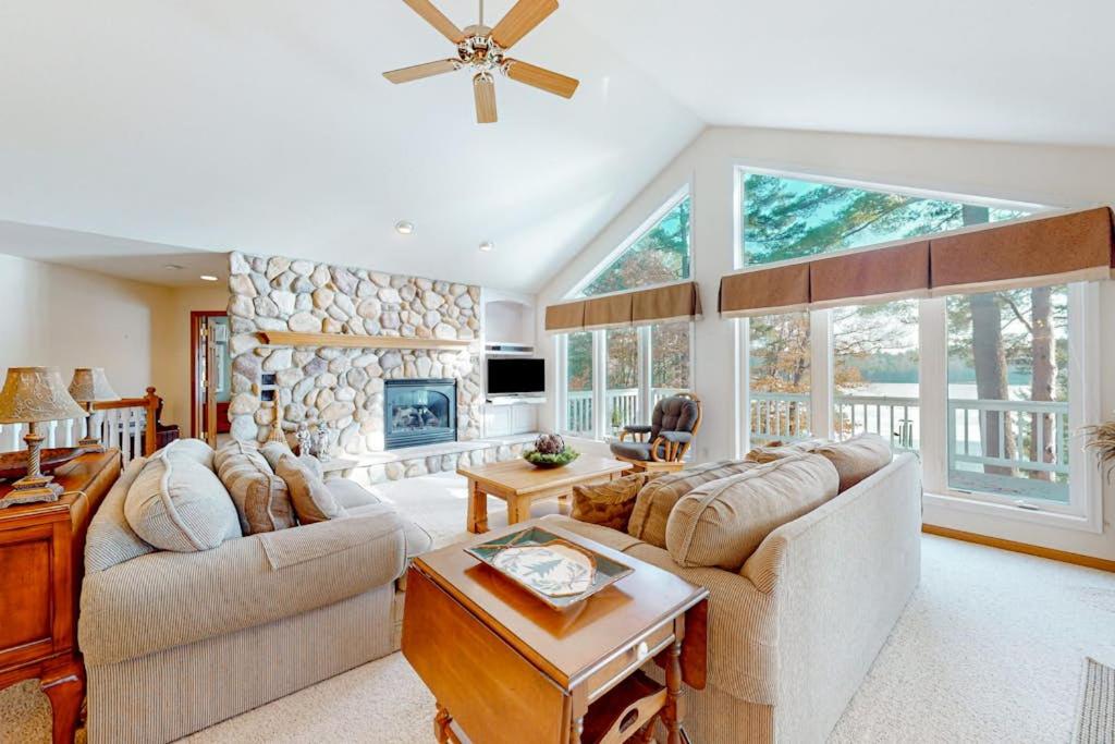 a living room with two couches and a stone fireplace at Yellow Birch Memories in Eagle River