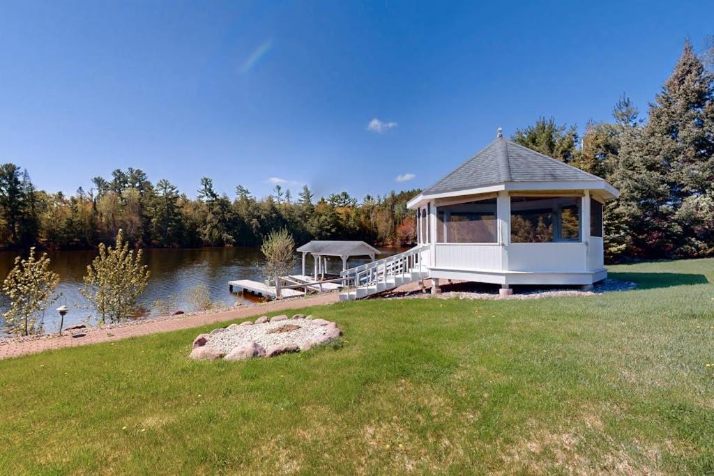 a white gazebo on the side of a lake at The 19th Hole Lakeside in Eagle River