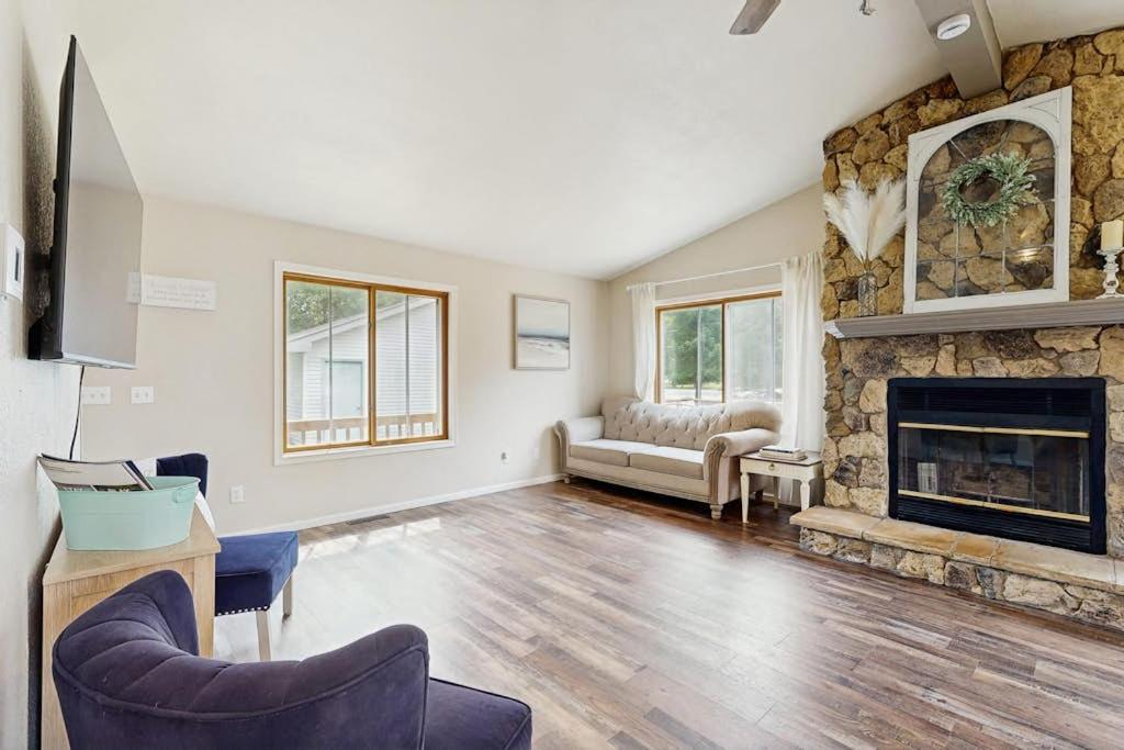 a living room with a stone fireplace and a couch at Rome Retreat- Steps from Beach & Golf in Nekoosa