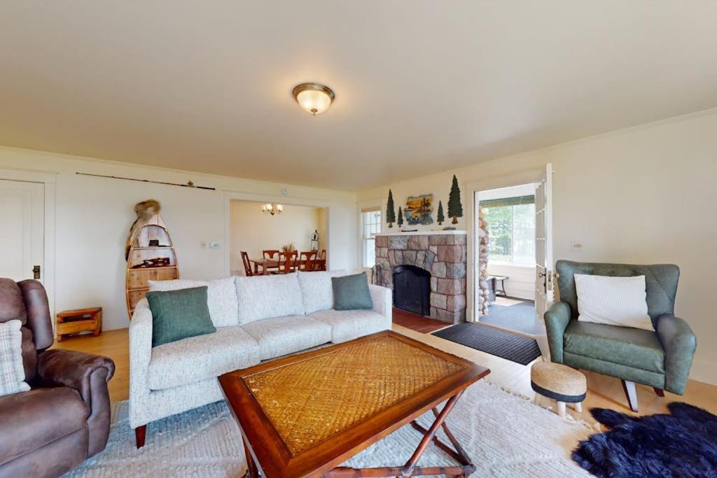 a living room with a couch and chairs and a fireplace at Flagpole Point in Phelps