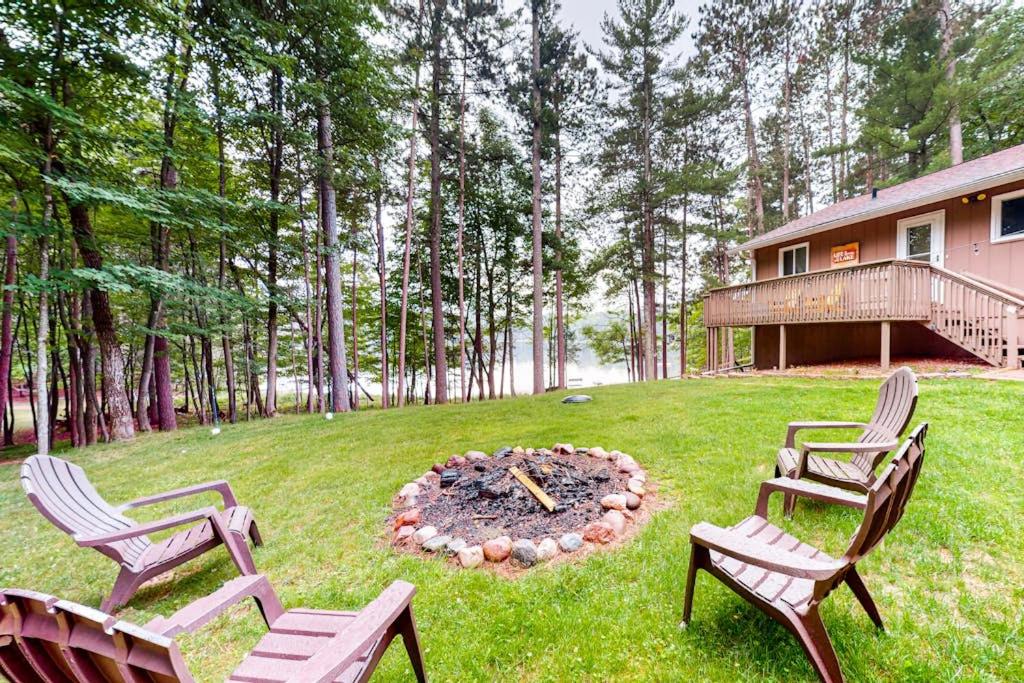 three chairs and a fire pit in a yard at Hillis House in Arbor Vitae