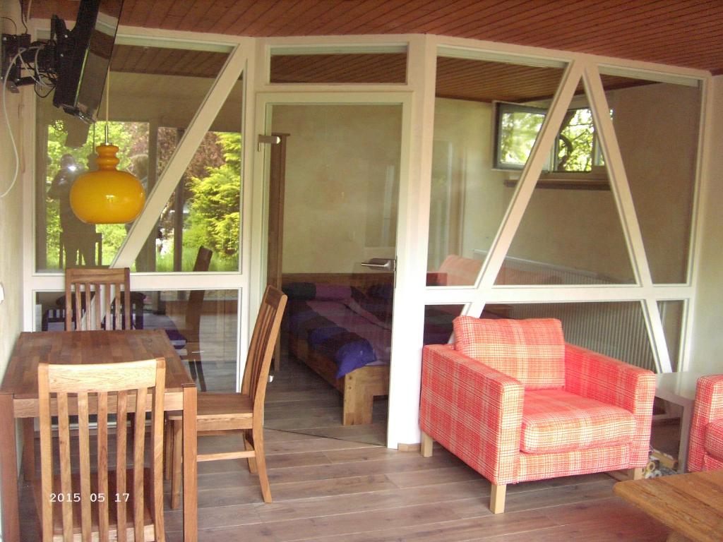 eine abgeschirmte Veranda mit einem Tisch und Stühlen in der Unterkunft Ferienwohnung Dähne in Allagen